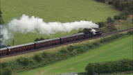 Steam Train Pass Under Bridge And Smoke Plumes Over Bank Top