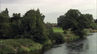 Low Shot Along River Reveals Kelham Hall And Church Behind Trees