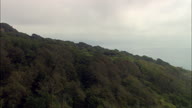 Lyme Revealed From Behind Tree Lined Cliff