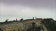 People Standing On Golden Cap With Pull Out