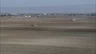 Two Tractors At Work In Field