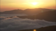 Clouds Stacked Up Against Mountains At Sunset